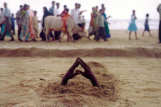 Ashish Gupta - A man buries himself under the sand, 2002. Juhu beach Mumbai, cm 45x69
