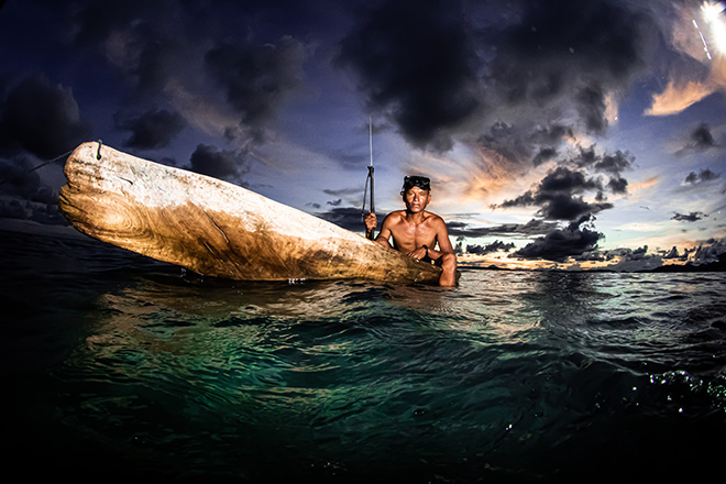 Ipah Uid Lynn - A member of the Bajau holds a fishing spear in a traditional wooden boat. Selakan Island, Malaysia. Female Fifty Fathoms Award, Ocean Photographer of the Year