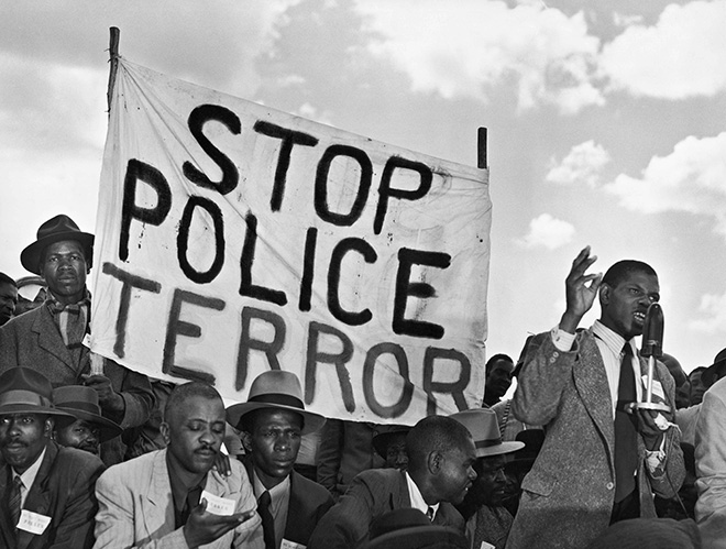 Margaret Bourke-White - Striscione sudafricano “Stop al terrore della polizia” durante un discorso nell’ambito della seconda riunione comunista, 1950. Margaret Bourke-White/The LIFE Picture Collection/Shutterstock