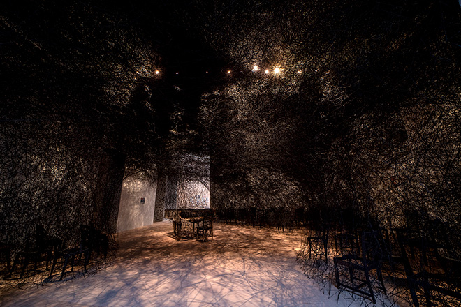 Chiharu Shiota - In Silence (« En silence »), 2002/2024. Piano brûlé, chaise brûlée, laine noire, Alcantara. Vue de l’exposition Chiharu Shiota. The Soul Trembles, Grand Palais, Paris 2024 Scenographie Atelier Jodar. © GrandPalaisRmn 2024 / Photo Didier Plowy © Adagp, Paris, 2024 and the artist.