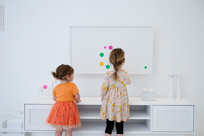 Visitors in Obliteration Room 2002, the Kids for Kusama exhibition at NGV International, Melbourne until 21 April 2025. © YAYOI KUSAMA. Photo: Eugene Hyland